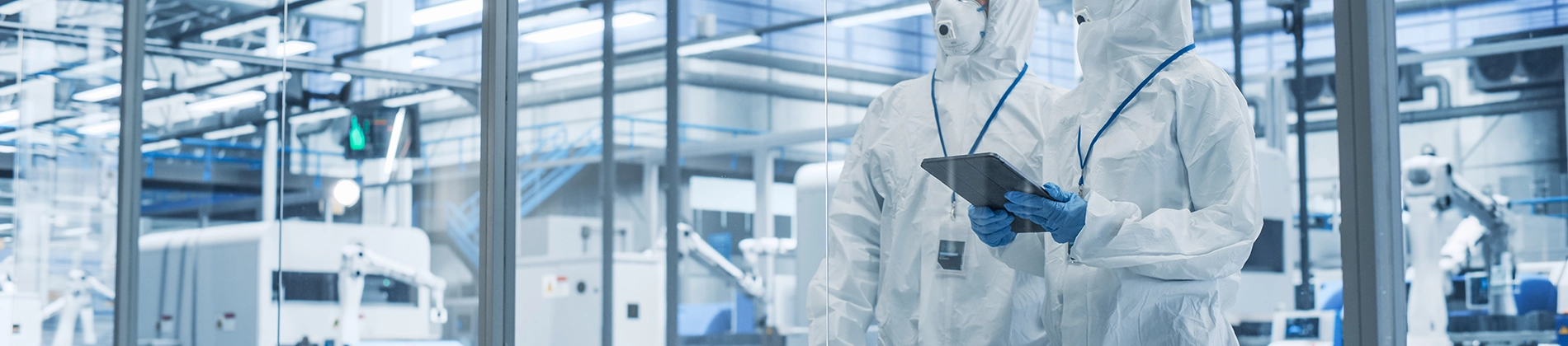 wide angle of scientists in cleanroom bunny suits working